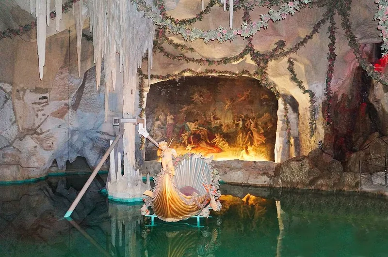 Ein vergoldetes Schwanenboot auf dem stillen grünen Wasser des unterirdischen Sees in der Venusgrotte